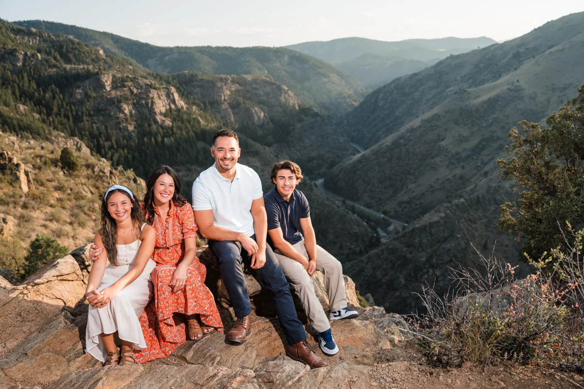 Caleb and his family sitting together in the Colorado mountains