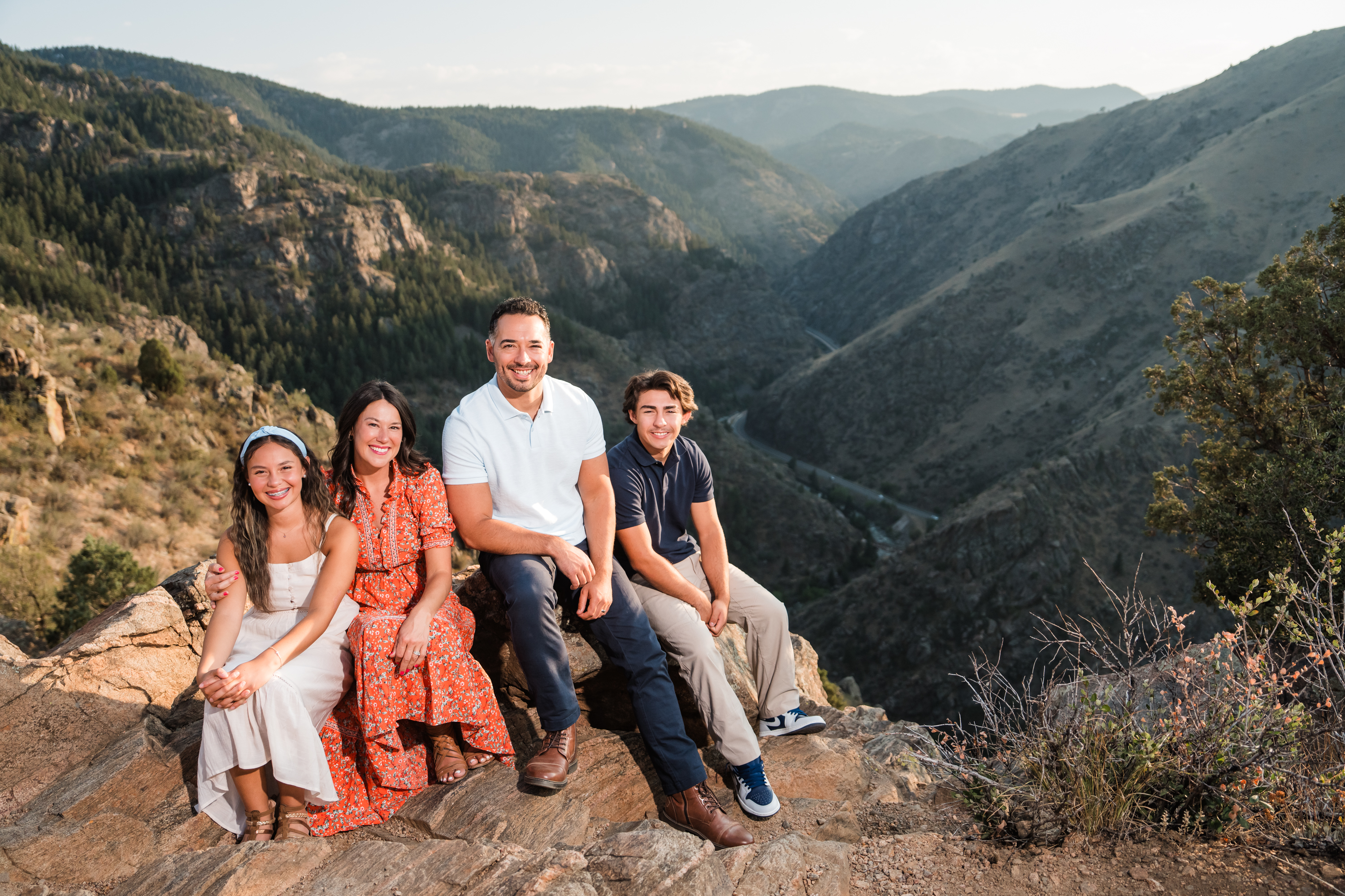 Caleb and his family sitting together in the Colorado mountains
